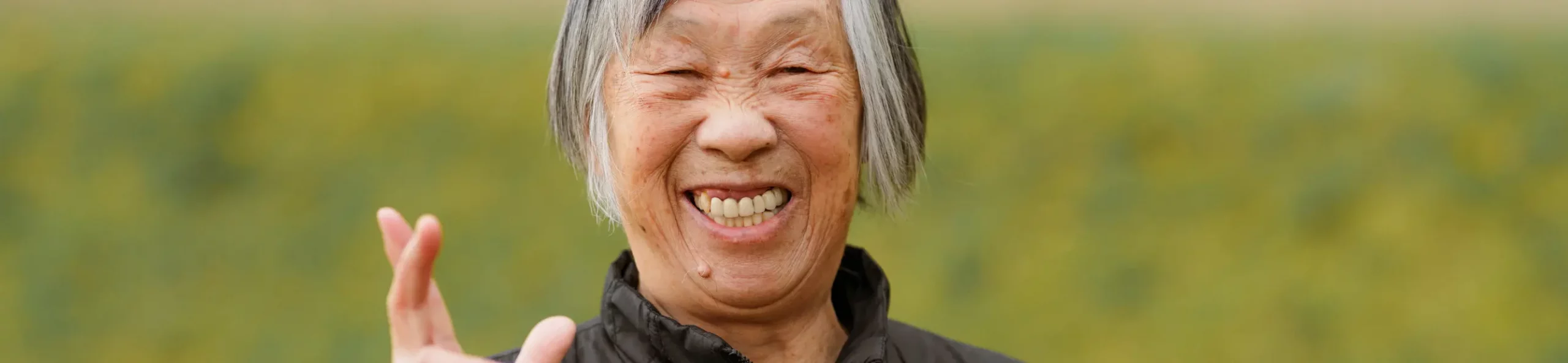 A senior tenant smiles broadly at the camera.